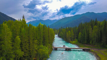 Aerial view of the bridge over the Kucherla river overlooking the forest and mountain ridge, Altai photo by drone