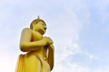 Beautiful Big Golden Buddha statue standing with sky background. Landscape size. Copy space