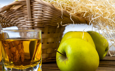 Green apples, basket with apples and jug with apple juice on wooden background