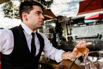 Young Latino entrepreneur having a glass of beer in a bar.
