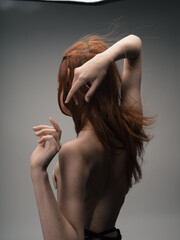 Nude red-haired woman touching herself with hands 