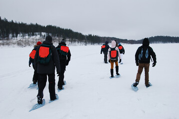 People in group walking on snow 