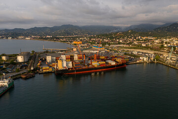 Batumi, Georgia - April 21, 2021: Ships in the port drone view on the background of sunset