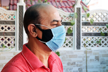 double mask prevent infection, mature indian man wearing two face mask to protect from new strain...