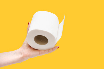 Toilet paper in hand. Roll of toilet paper in hand on a yellow background.