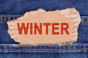 A cardboard box with the inscription- WINTER sticks out of jeans.