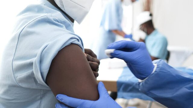 Professional Doctor Injecting Coronavirus Vaccine To Male Patient In The Hospital. medium shot