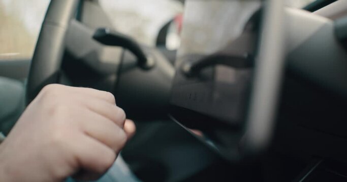 Close up of hands swiping on a touchcreen in an electric car