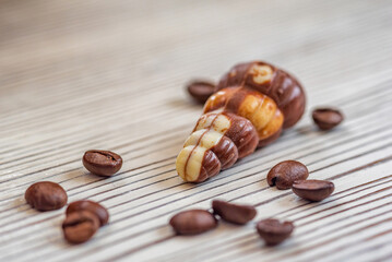 Figures of Belgian chocolate on a light wooden background close-up.
