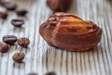 Figures of Belgian chocolate on a light wooden background close-up.