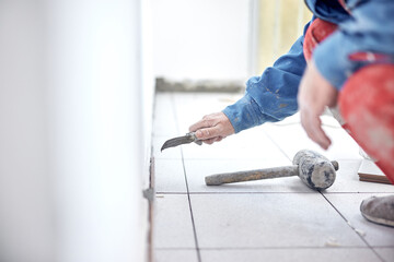 Ceramics tile man worker placing new tiles on the floor and wall.