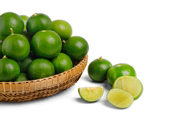 Fresh green limes in bamboo basket isolated on white background. Whole pieces and sliced.