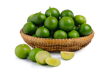 Fresh green limes in bamboo basket isolated on white background. Whole pieces and sliced.