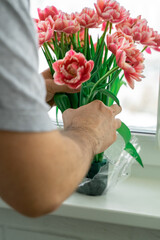 a man picks up a bouquet of flowers made with a sponge