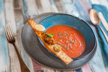 Fresh gazpacho and a toast with quail egg and anchovy