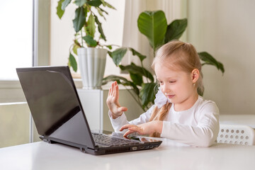 The girl learns (communicates, talks) through a computer / laptop