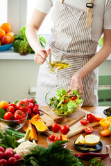Beautiful young woman preparing delicious fresh vitamin salad with olive oil. Concept of clean eating, healthy food, low calories meal, dieting, self caring lifestyle. Colorful vegetables. Close up