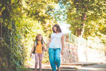 Go to school. Little girl walking to school with her mother.