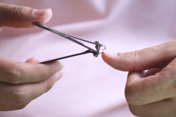 A woman's hand holding a nail clipper is cutting her nails to keep them hygienic. The concept of personal hygiene care to reduce the chance of illness.