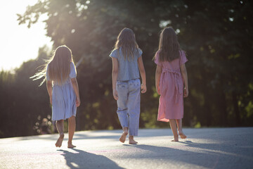  Three little girls walking trough nature together.