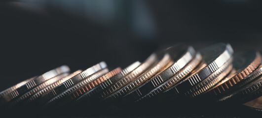Close up of row of coins on dark background for business and finance concept