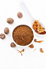 Nutmeg ground in bowl and mace in spoon on board top