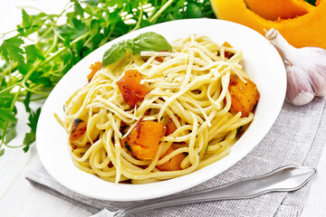 Spaghetti with pumpkin in plate on white board