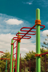 green and red horizontal bars on a playground in the summer
