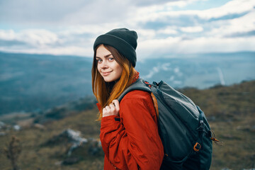 young traveler with backpack and mountains in the background landscape sky clouds