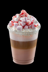 Iced coffee with whipped cream, ice cream and topping in a cardboard glass, black background, isolate