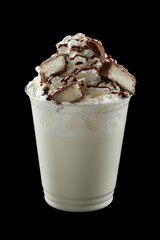Iced coffee with whipped cream, ice cream and topping in a cardboard glass, black background, isolate