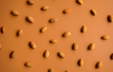 pattern of almonds arrange on brown background 