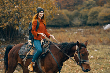 Obraz premium woman hiker riding horse mountains landscape travel adventure