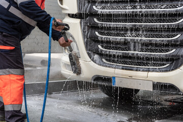 Truck driver cleaning the exterior of the vehicle.