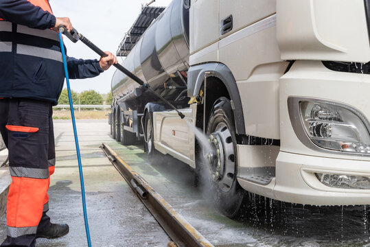 Tank truck driver cleaning the exterior of the vehicle.