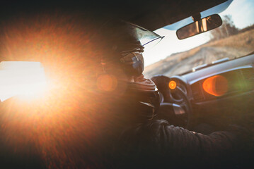 Rally racer in a helmet is driving a car concept.