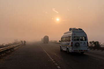 Indian Road Highways, Beautiful landscape of Indian roads during fog and sunrise in winter morning. Vehicles running on highways.