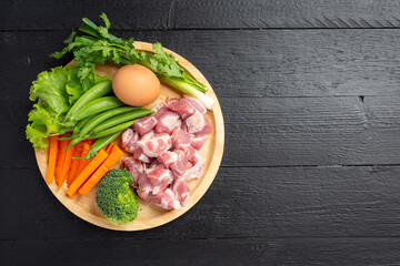 Healthy fresh pet food ingredients on dark background
