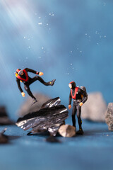 Miniature people , Scuba diver cleans up plastic rubbish pollution discarded in ocean, underwater pollution concept