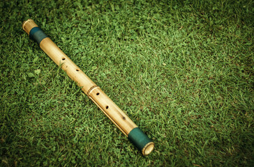 Bamboo flute on the green grass in the garden, time for relaxation © Svetliy