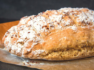 Freshly baked traditional soda bread sprinkled with flax seeds on parchment paper