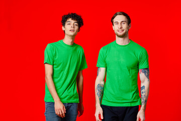 two friends in green t-shirts communication lifestyle red background