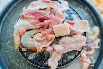 Close up of Thai Barbecue Buffet Pork meat and seafood on the hot pan, Moo Ka Ta