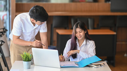 Two young designer discussing new project together in office.