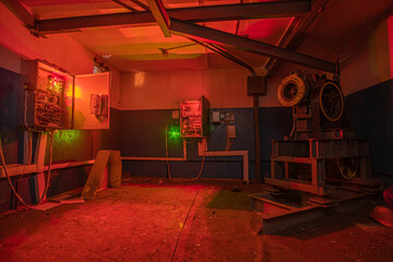 Interrior of old engine room of the elevator is illuminated by electrical appliances. - obrazy, fototapety, plakaty