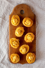 Homemade Deep-fried Deviled Eggs with Paprika on a rustic wooden board, top view. Flat lay, overhead, from above.