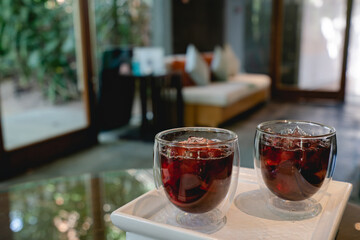 Welcome drink red mocktail and served on white wooden tray.