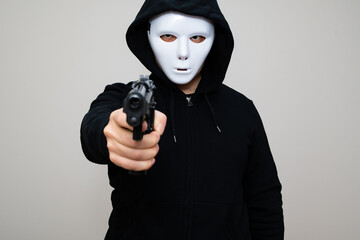 Hacker with anonymous mask holding a gun