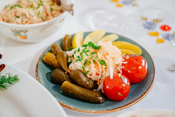 traditional Russian snacks. pickled cabbage, and tomatoes with boiled potatoes. serving the table. Cooking for a festive dinner.
