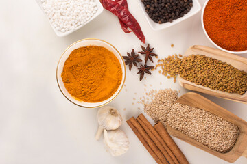spices in ceramic bowls, wooden spoons and on ground With white background stock photo